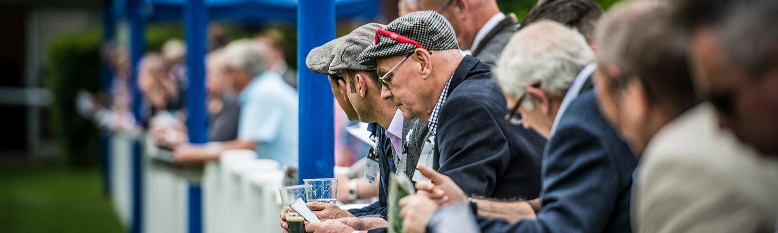 Punters analysing their racecards during a race at Royal Windsor Racecourse