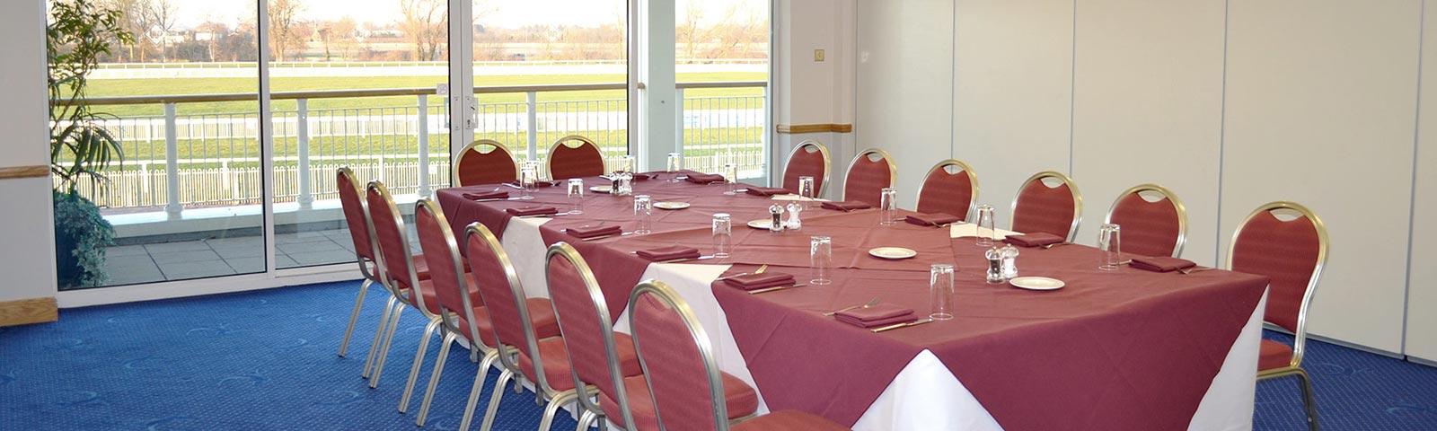 A clean neatly prepared table with glasses and cutlery awaits the days guests.