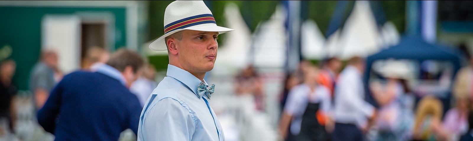 A gentleman wearing a hat at the races at Windsor Racecourse.