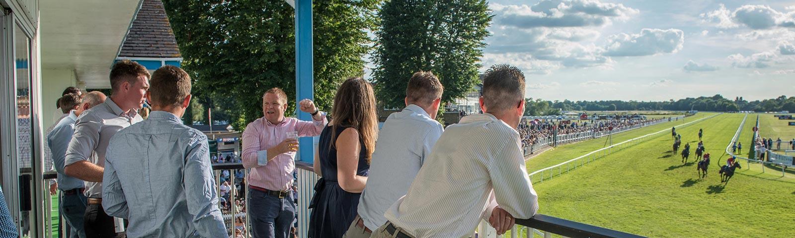 Friends get a great view of the racing action from the balcony within the Paddock Pavilion Boxes at Royal Windsor Racecourse.
